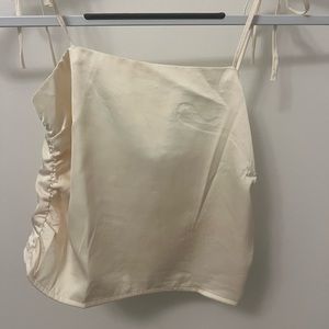 Cream satin tank top with ruching and zipper back closure.